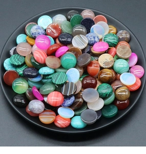 Detailed macro view of assorted 16mm round semi-precious stone cabochons for DIY jewelry