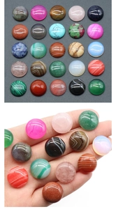 Macro shot of assorted 16mm round natural crystal cabochons showing various stone textures