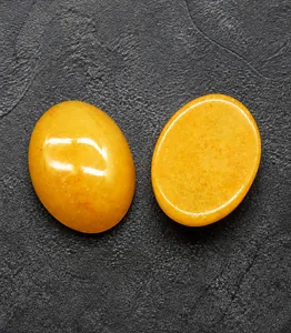 Macro de deux pierres précieuses ovales en quartz jaune pour bijoux sur fond sombre