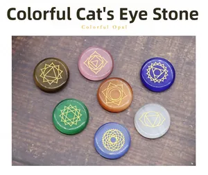 Detailed overhead view of seven colorful opal chakra stones with gold engraved yoga symbols