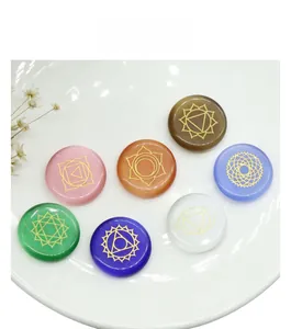 Detailed view of seven polished chakra opal discs with gold engraved yoga symbols
