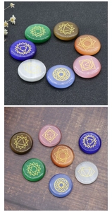 Flat round chakra healing stones with golden yoga symbol engravings on dark backgrounds