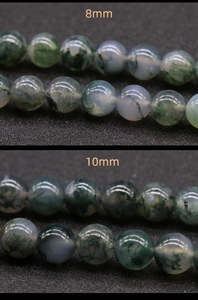 Macro detail of 8mm and 10mm moss agate beads with green mineral inclusions for DIY