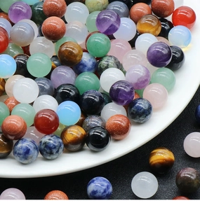 Vue détaillée de perles en pierres gemmes comme l'améthyste et l'œil de tigre en bol