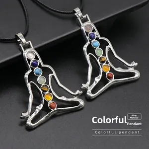 Detailed macro view of two silver alloy yoga chakra pendants with colorful energy stones