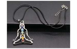 Macro shot of silver yoga meditation pendant with seven colorful chakra stones on black cord