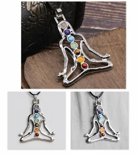 Macro detail of silver yoga meditation pendant with seven colorful chakra gemstones