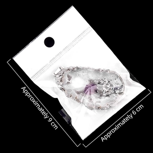 Pendentif géode d'agate avec cristaux violets et bordure argentée sur fond noir