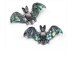 Détail macro d'une broche chauve-souris gothique avec ailes en nacre d'abalone naturelle