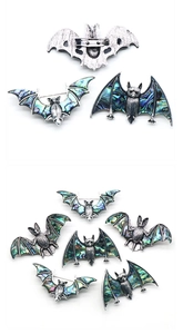 Détail d'une broche chauve-souris avec nacre d'abalone irisée et monture en alliage argenté