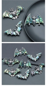 Détail de broches chauve-souris en argent vintage avec incrustation d'abalone irisée