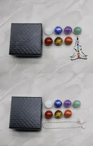Set detallado de siete esferas de cristal chakra con péndulo de metal en caja negra