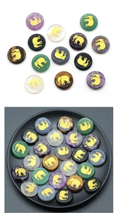 Macro detail of mixed natural gemstones with golden elephant engraving for DIY crafts