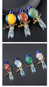 Dettaglio di spille a forma di pappagallo in smalto colorato con diverse pietre naturali