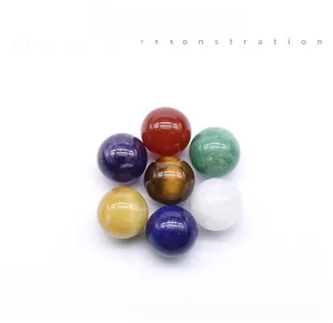 Macro shot of seven polished natural crystal and agate chakra stone spheres on white background