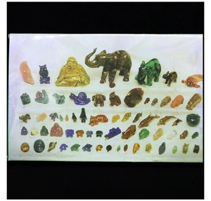 Variety of hand-carved gemstone animal figurines including elephants and owls