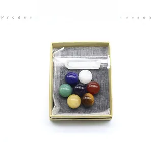 Detail showing seven polished chakra crystal balls with a selenite stick and mesh bag
