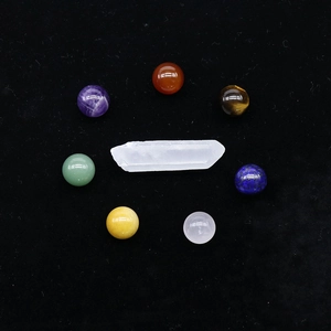 Chakra stone set featuring white crystal wand and seven colorful agate spheres on black velvet