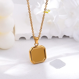 Macro detail of gold square photo frame pendant with metal insert on elegant white background