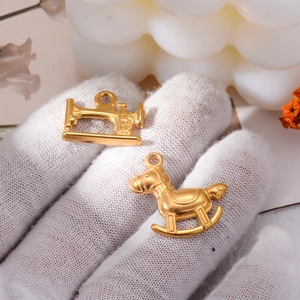 Details von goldenen Nähmaschinen- und Schaukelpferd-Anhängern für DIY-Schmuck