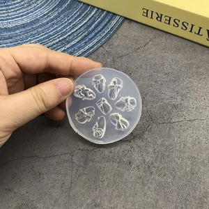 Macro detail of round translucent silicone nail art mold with 8 bow designs for DIY