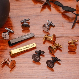 Customized cufflinks and tie clips set in four metal finishes on a wooden desk
