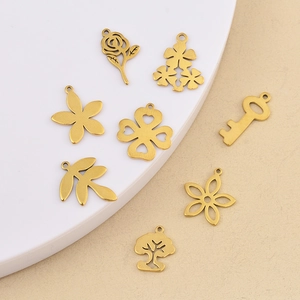 Vue détaillée de breloques en acier doré avec motifs fleurs et trèfles pour bijoux DIY