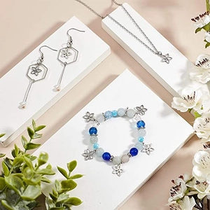 Détail d'un ensemble bracelet à perles bleues et collier à fleurs sur blocs blancs