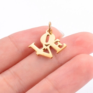 Pendentif LOVE en acier inoxydable doré tenu entre les doigts pour la taille
