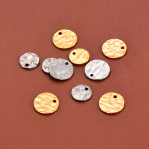 Vista macro de colgantes redondos de metal martillado en oro y plata para joyería DIY