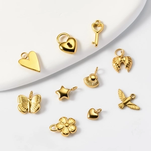 Set de dijes de acero inoxidable dorado con formas de corazón, mariposa y flores