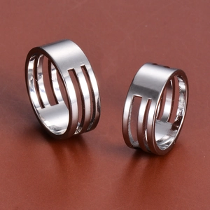 Macro shot of silver stainless steel open ring with triple parallel vertical cutouts