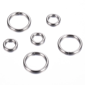 Detailed view of polished stainless steel jump rings in various sizes for DIY jewelry