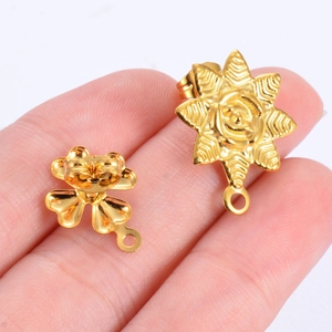 Vista de mano de pendientes de acero inoxidable dorados con diseño de hoja y flor DIY