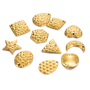Macro-opname van diverse gouden gehamerde rvs geometrische bedeltjes voor DIY sieraden