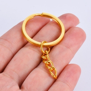 Anillo de llavero de metal dorado pulido de 25mm con cadena de cuatro eslabones en mano