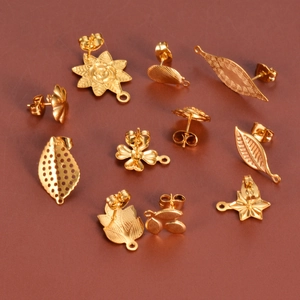 Vista macro de varios componentes de aretes de acero inoxidable dorado en forma de hoja