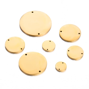 Flat lay of multiple sized mirror polished gold stainless steel round double hole charms