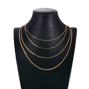 Four-piece golden square snake chain necklaces set in varying lengths on a black model