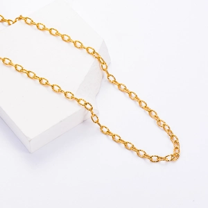 Polished gold stainless steel oval link chain necklace displayed on a white stone pedestal
