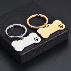 Polished bone-shaped stainless steel keychains with hollow paw prints in gold and silver