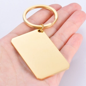 Polished gold rectangular stainless steel blank keychain being held in hand
