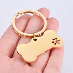 Polished gold bone-shaped keychain with hollow paw print detail for pets and keys