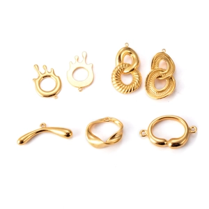 Detalle de varios conectores geométricos de acero inoxidable dorado para joyería