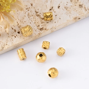 Detailed view of assorted 18k gold plated titanium steel beads for jewelry making