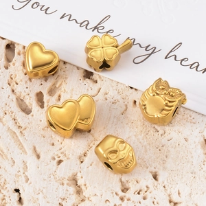 Detailed macro shot of golden stainless steel heart and owl charms for jewelry making