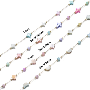 Detailed view of colorful shell beads in star and cross shapes on a gold chain
