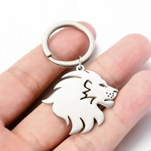 Western style stainless steel lion head pendant keychain held in hand for size reference