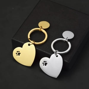 Polished stainless steel heart keychain with hollow dog paw print in gold and silver