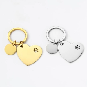 Polished stainless steel heart-shaped pet ID keychain with hollow paw print in gold and silver